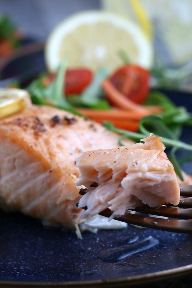 A close up view of the finished healthy salmon recipe on a fork ready to be eaten. 