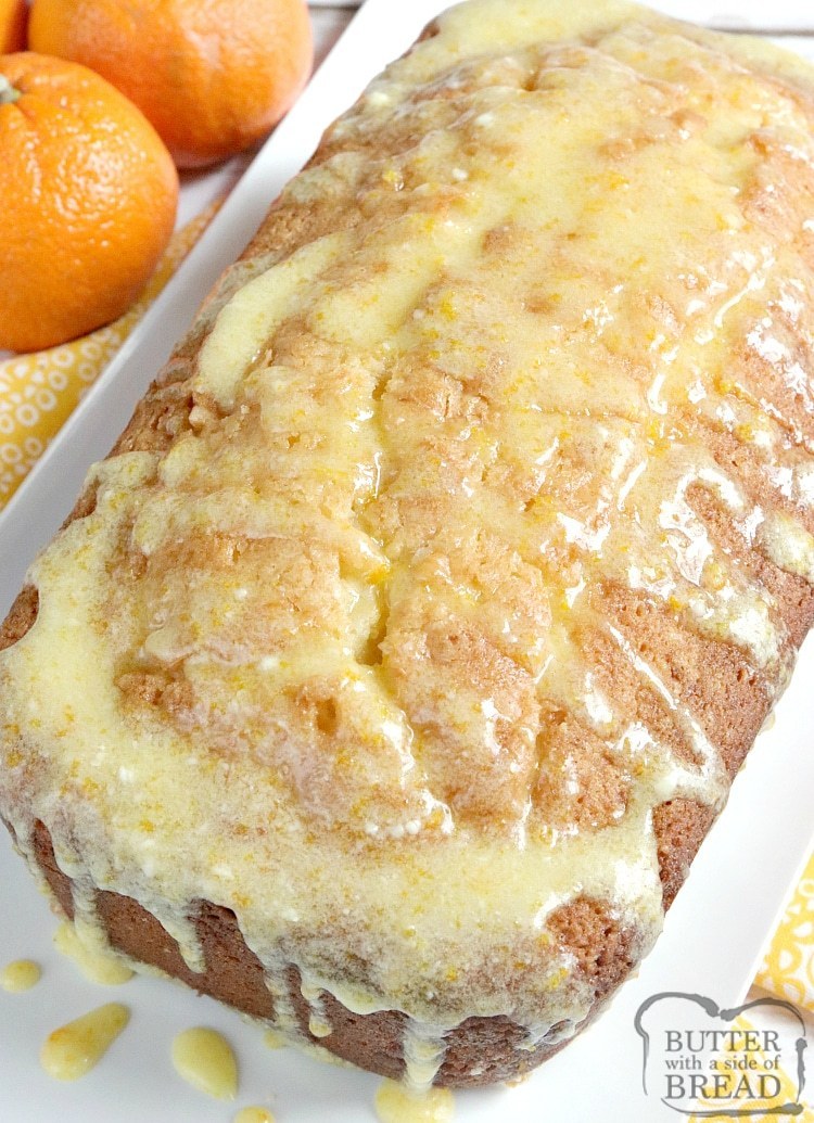 Loaf of orange quick bread with orange glaze on top.