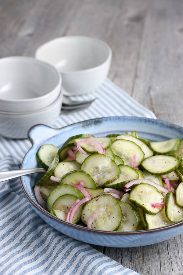 a blue bowl filled with cucumber salad