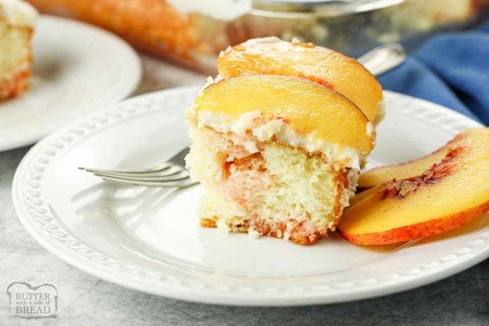 slice of poke cake with fresh peach slices on top