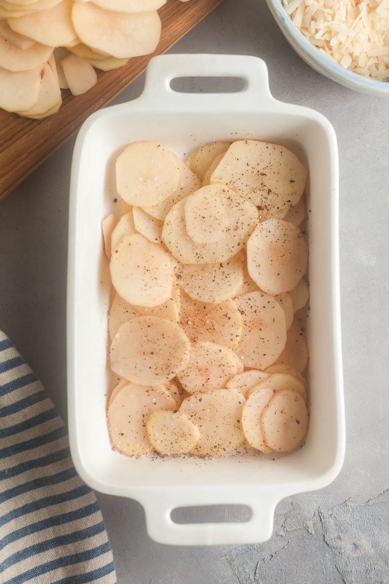 layer the potatoes in a casserole dish and season with salt and pepper