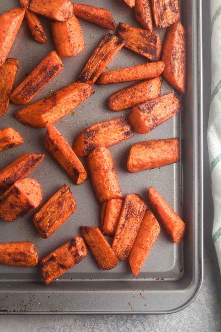 Seasoned Carrots on a sheet pan, ready for roasting