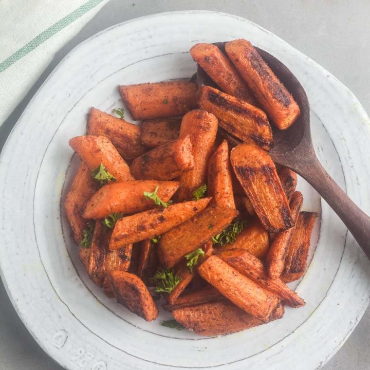 Overhead view of Moroccan roast carrots in a white serving dish