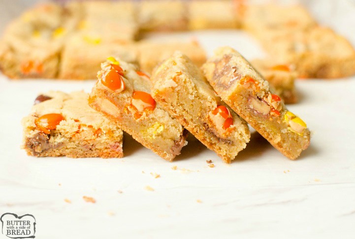 Reese's Cookie Bars are a thick, chewy & full of Reese's Pieces and Mini Reese's Cups! The rich, chewy cookie bar compliments the chocolate & peanut butter add in's perfectly. No rolling required, Cookie Bars are the way to go!